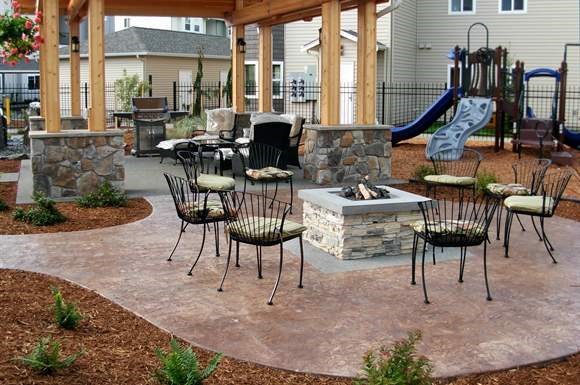a patio with chairs and a fire pit