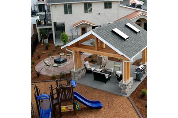 a backyard with a playground and a covered patio