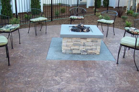 a patio with a fire pit and tables and chairs