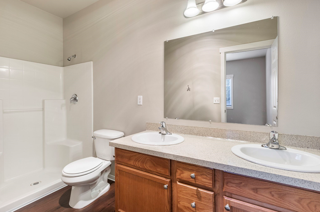 an empty bathroom with a toilet sink and mirror