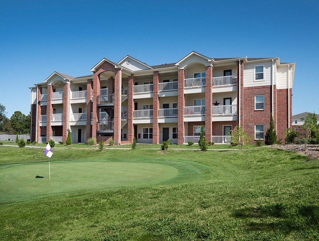 an apartment building with a golf course in front of it