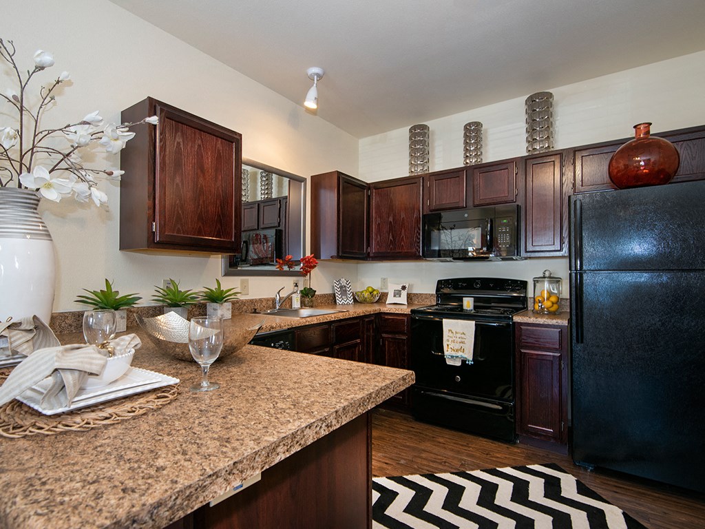 a kitchen with black appliances and a granite counter top