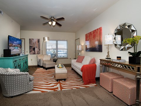 a living room filled with furniture and a ceiling fan