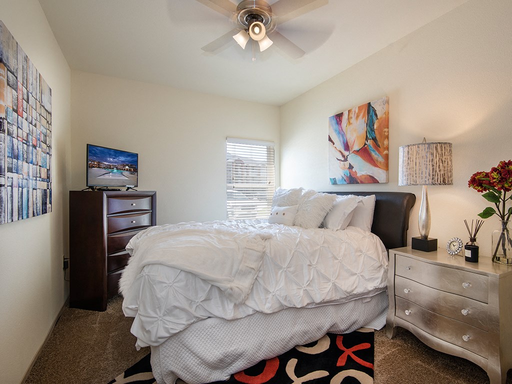 our apartments offer a bedroom with a bed and a ceiling fan