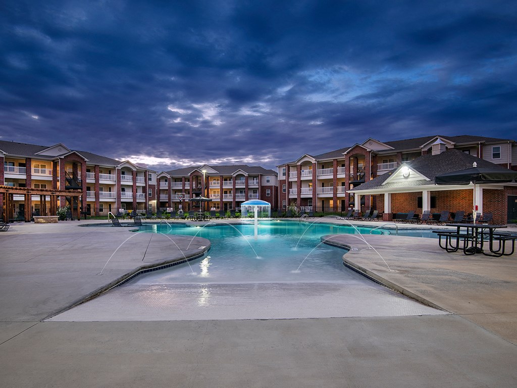 an empty swimming pool with an apartment building in the background