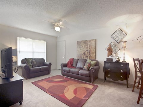 a living room with furniture and a ceiling fan
