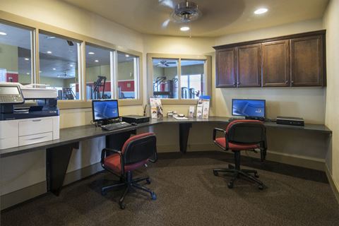 an office with two desks with computers and chairs