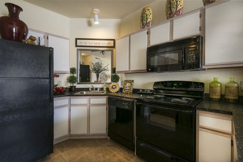 a kitchen with black appliances and white cabinets