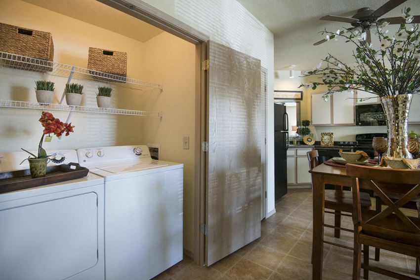 a white washer and dryer in a kitchen next to a dining room table