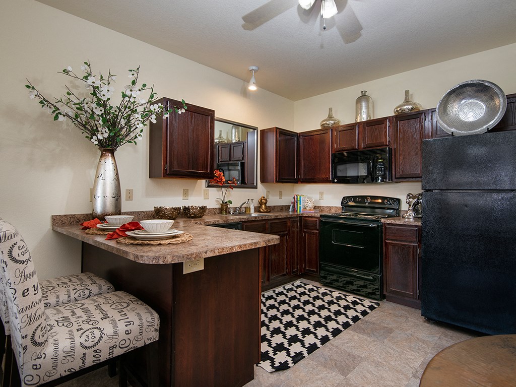 a kitchen with a granite counter top and a black refrigerator