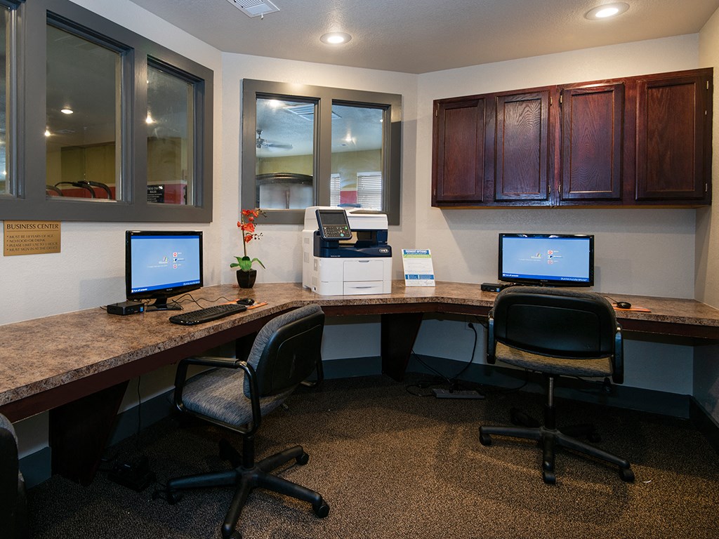 two desks with computers and a printer in an office