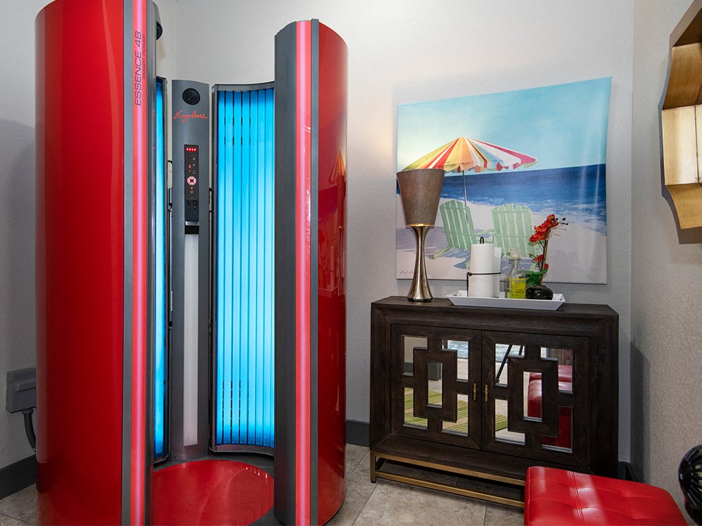 a living room with a red refrigerator and a painting of the beach