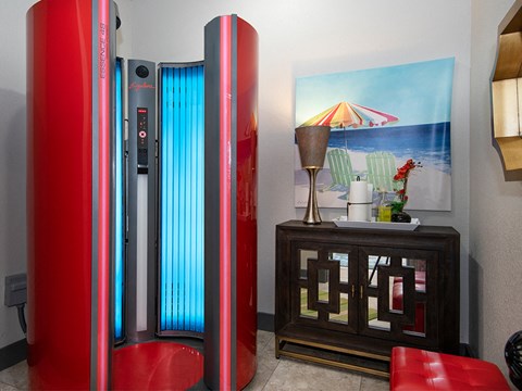 a living room with a red refrigerator and a painting of the beach