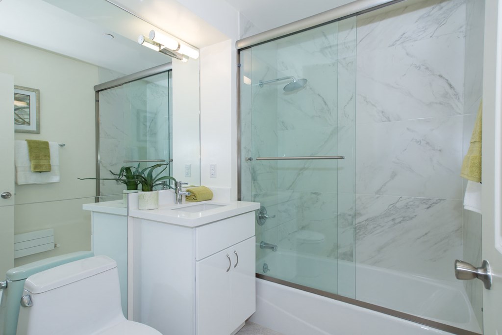 A white bathroom with a glass shower door.