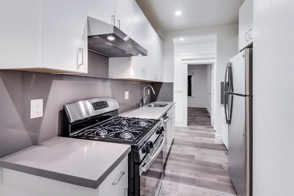 A modern kitchen with a stove top oven and a refrigerator.