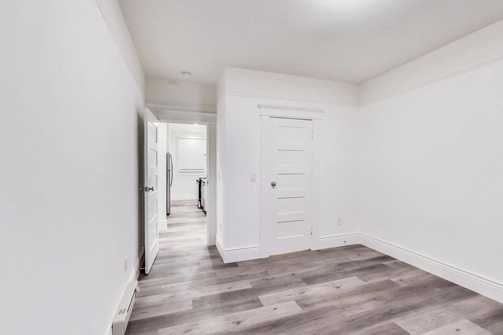 A long hallway with a white door at the end.