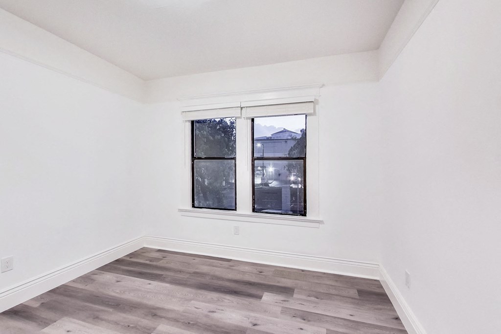 A room with a window and wooden flooring.