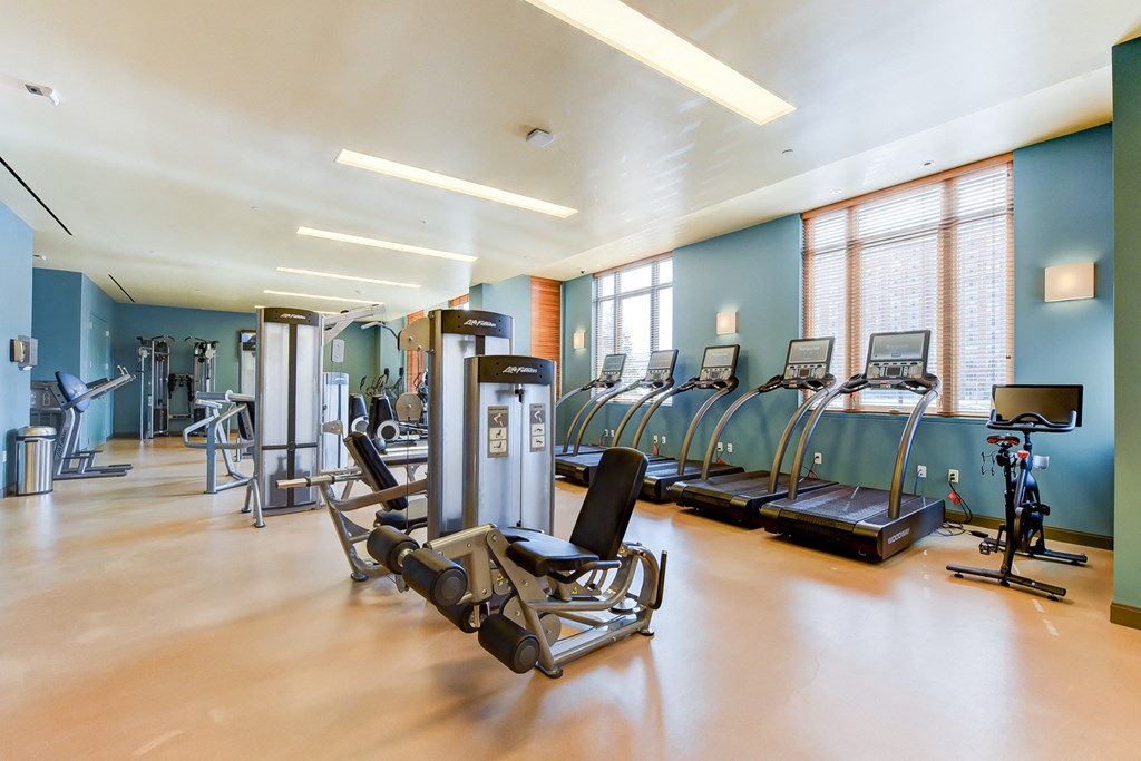 a fitness room with cardio machines and weights