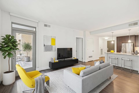 A modern living room with a grey sofa and yellow accents.