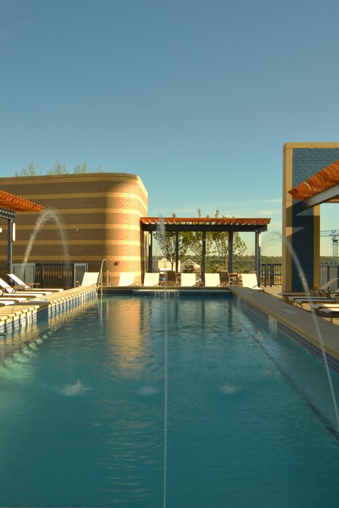 A swimming pool with a clear blue water and a building in the background.
