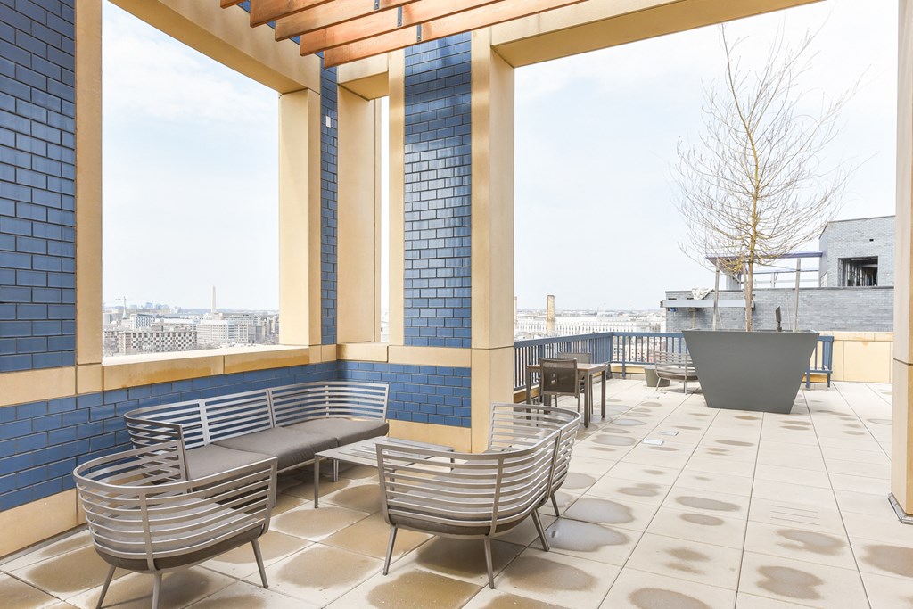 the terrace of a building with chairs and a tree