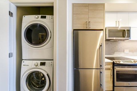 a kitchen with a washing machine and refrigerator and a stainless steel refrigerator