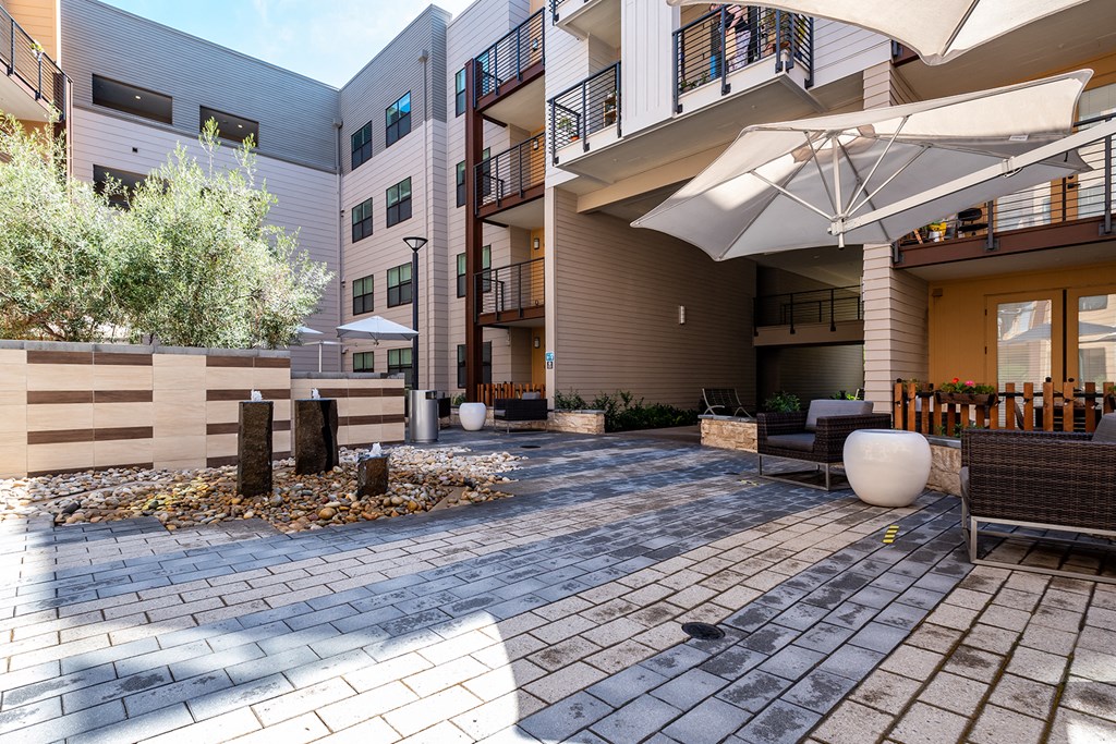 Apartments for Rent in Sunnyvale, CA-6TenEast-Courtyard with Umbrellas, Lounge Seating, Greenery, and Paved Walkways