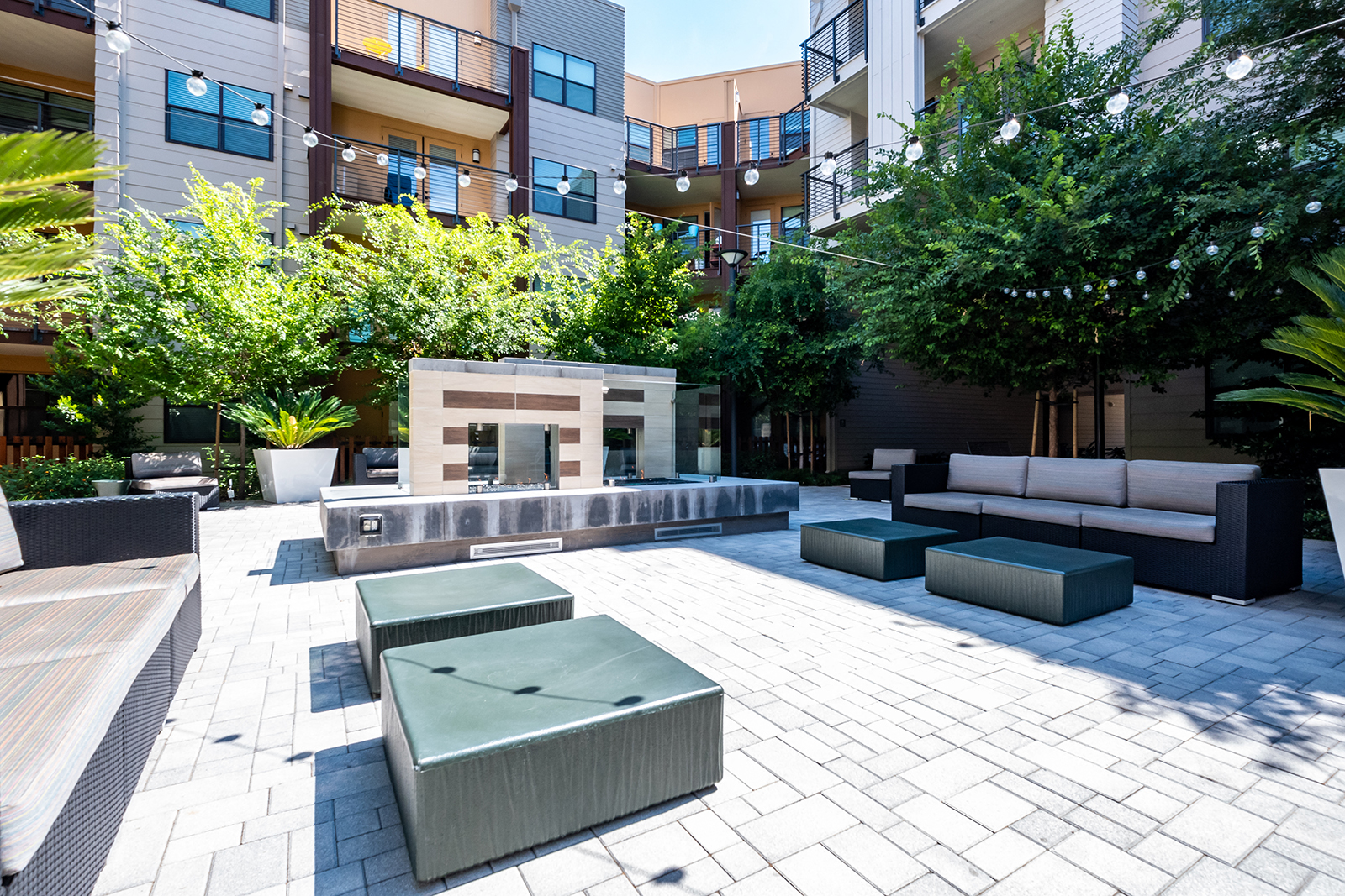 a courtyard with couches and tables and a fire pit