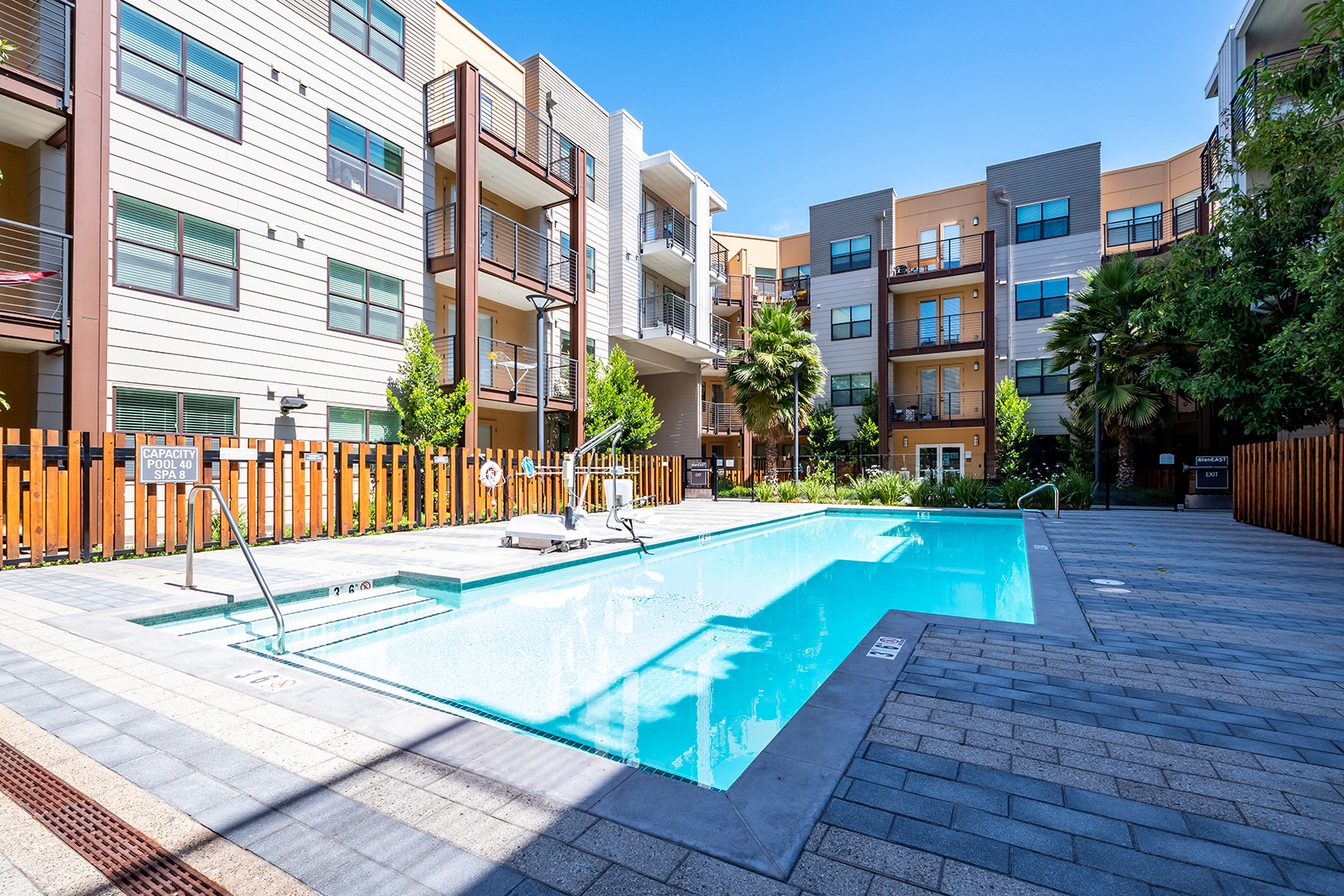 an apartment pool with an apartment building in the background