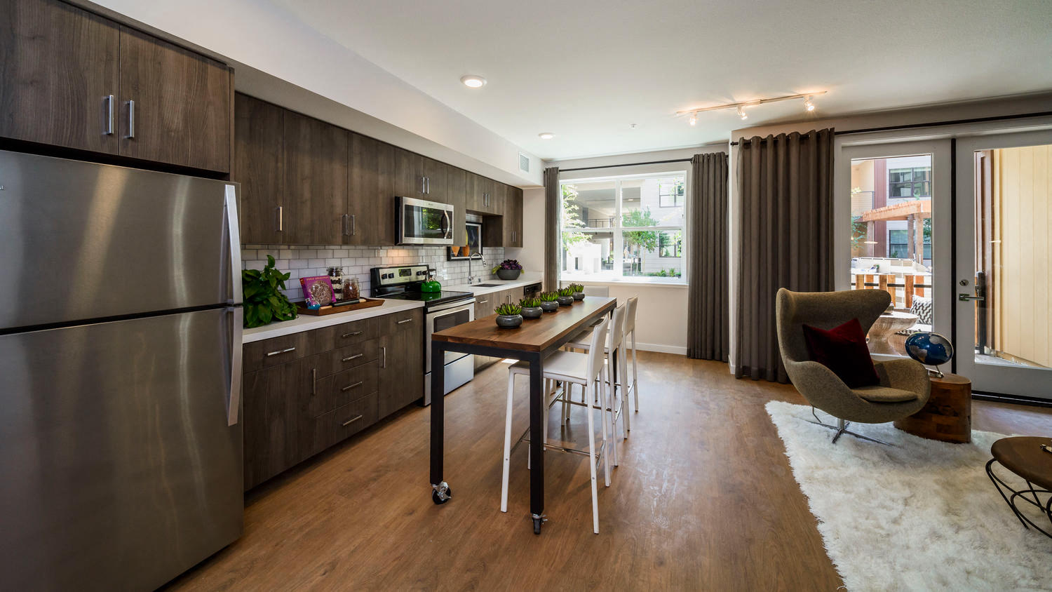 Sunnyvale Apartments-6TenEast-Kitchen with Hardwood Style Flooring, Stainless Steel Appliances, Large Windows, and Overhead Lighting