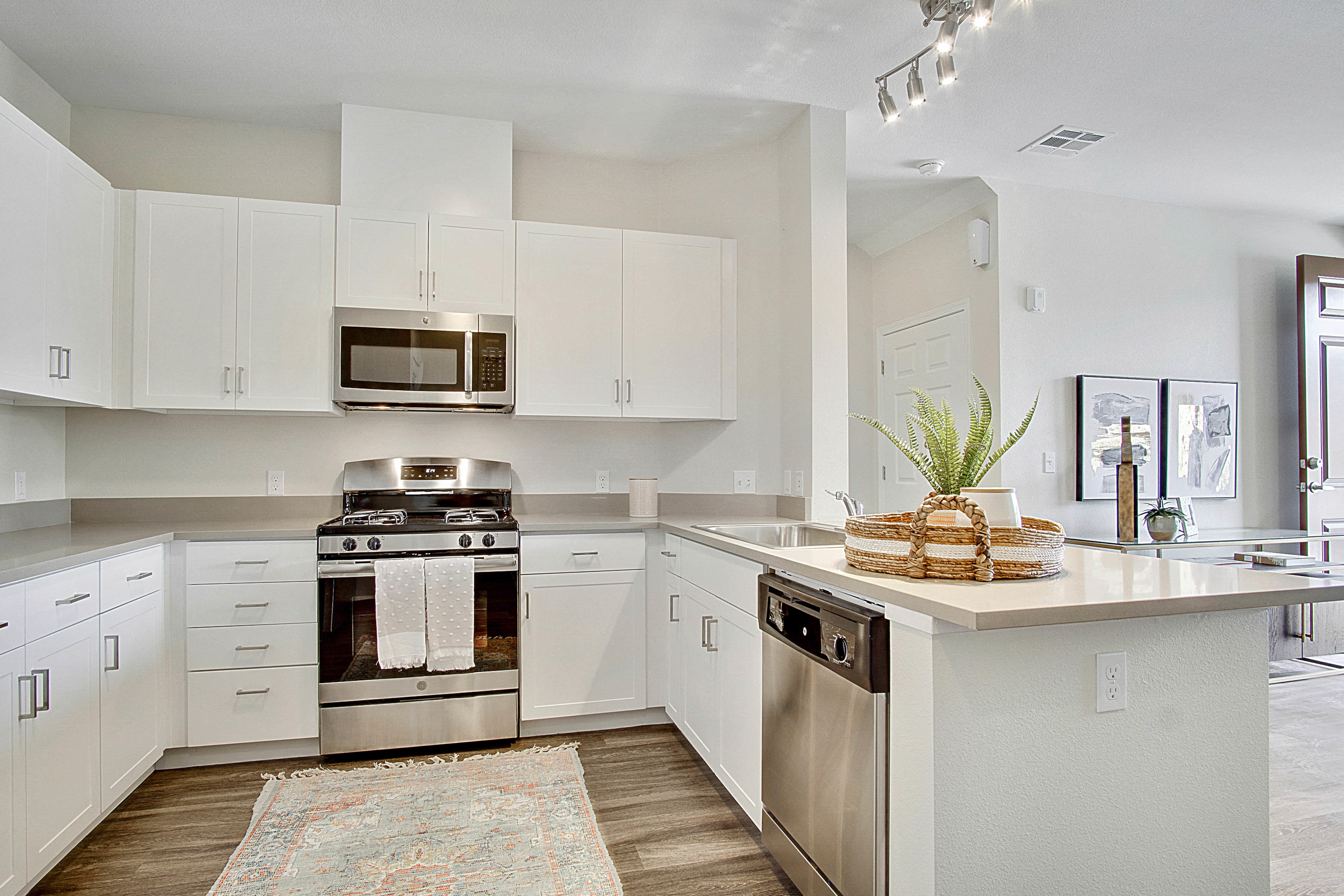 Apartments for Rent in Reno, NV - Vida Apartments Kitchen with White Caninetry, Stainless Steel Appliances, & Hardwood Floors