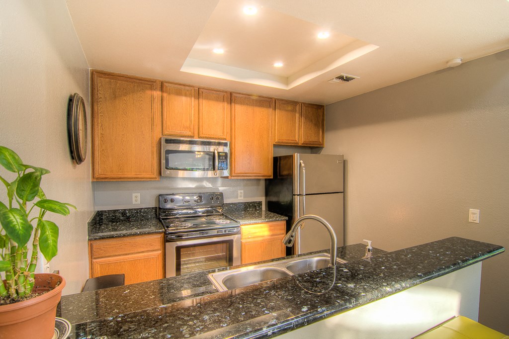 a kitchen with granite counter tops and stainless steel appliances