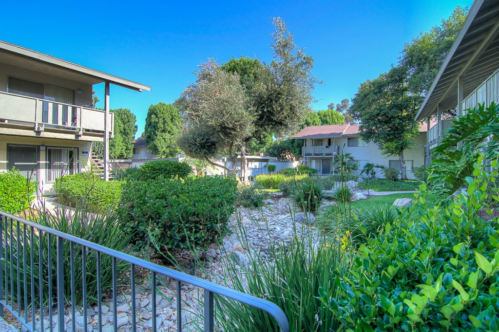 a view of a garden between two apartment buildings