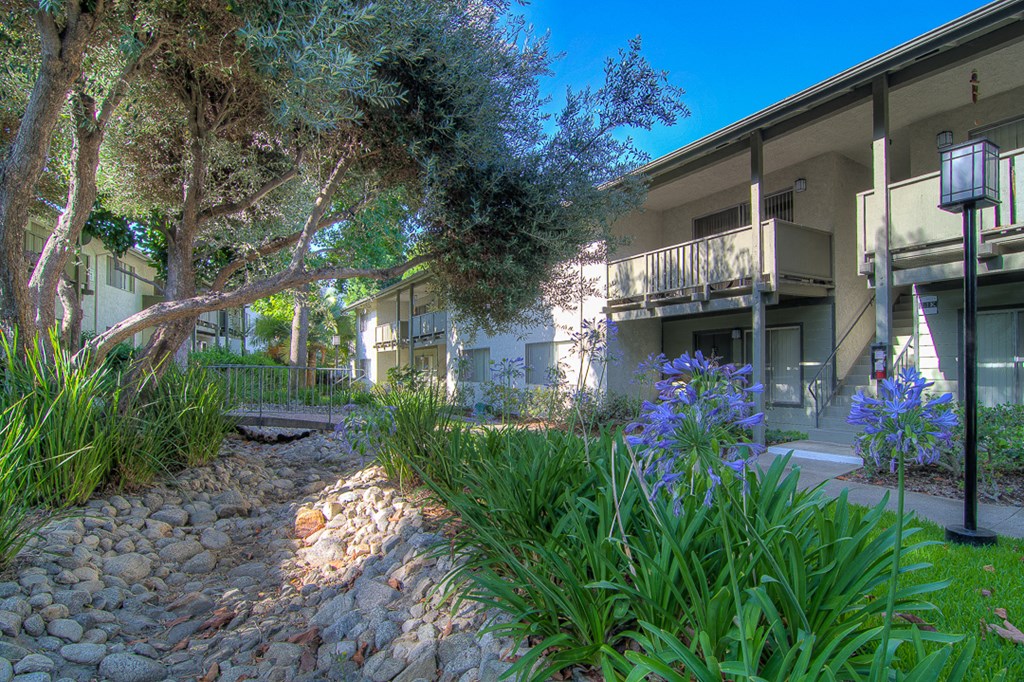 a building with trees and flowers in front of it