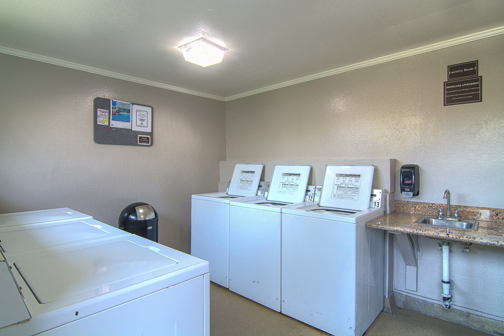 a laundry room with washer and dryer and a sink