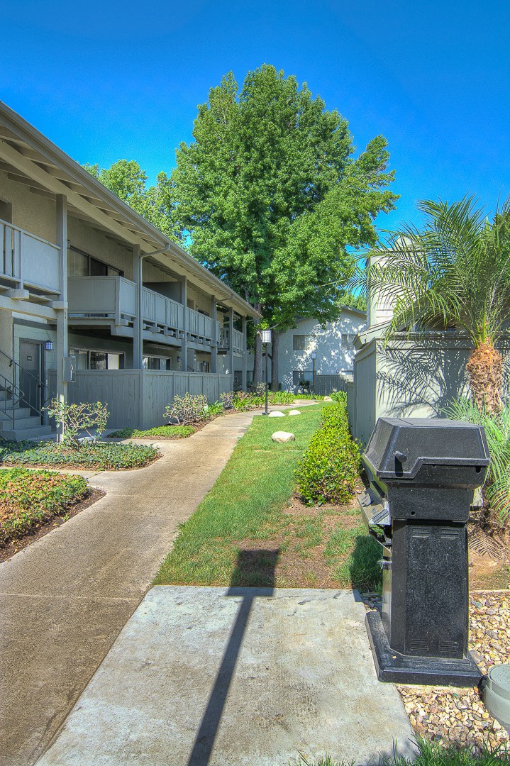 a courtyard between two buildings with a sidewalk and a fire hydrant
