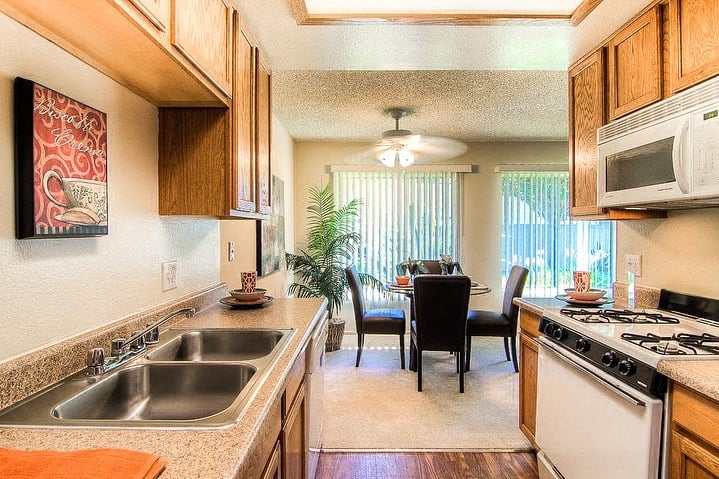 a kitchen with a sink and a stove and a dining room