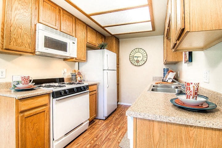 a kitchen with a stove refrigerator and sink