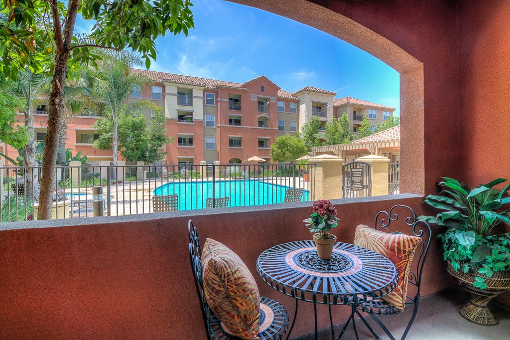 a patio with a table and chairs overlooking a swimming pool