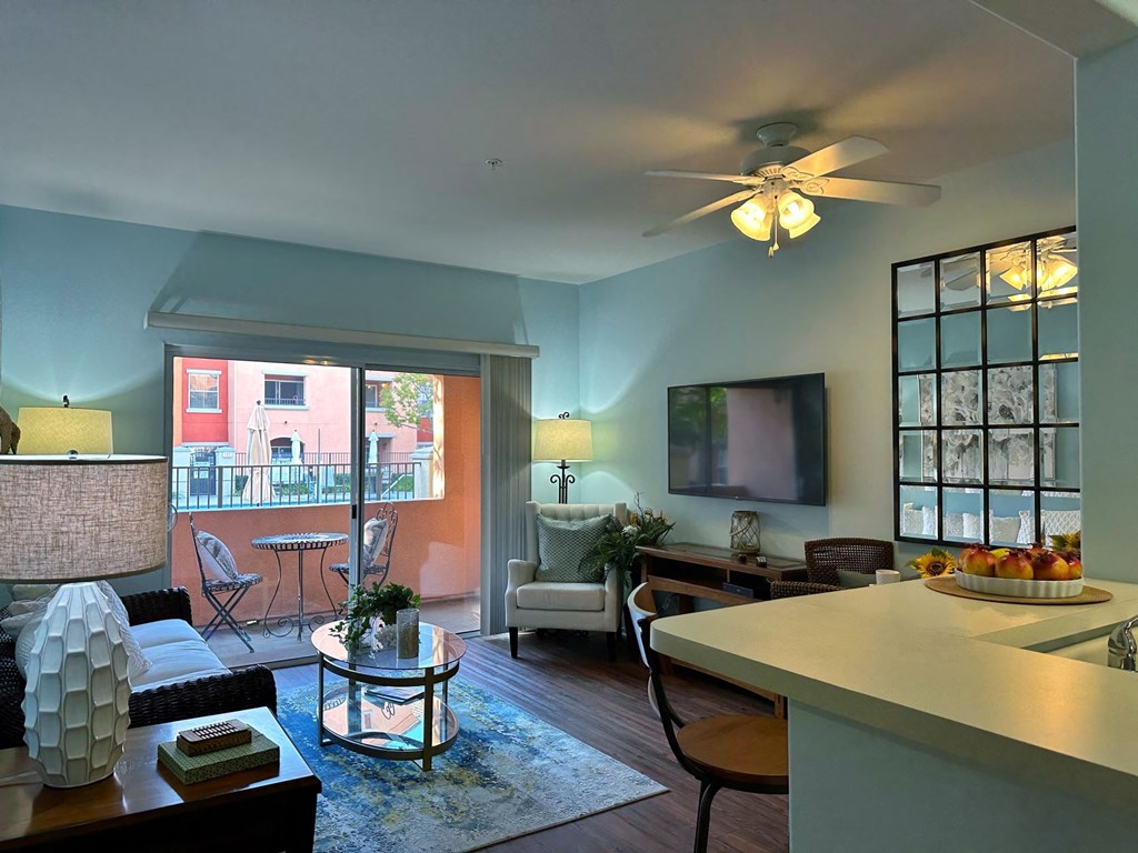 a living room with a ceiling fan and a balcony