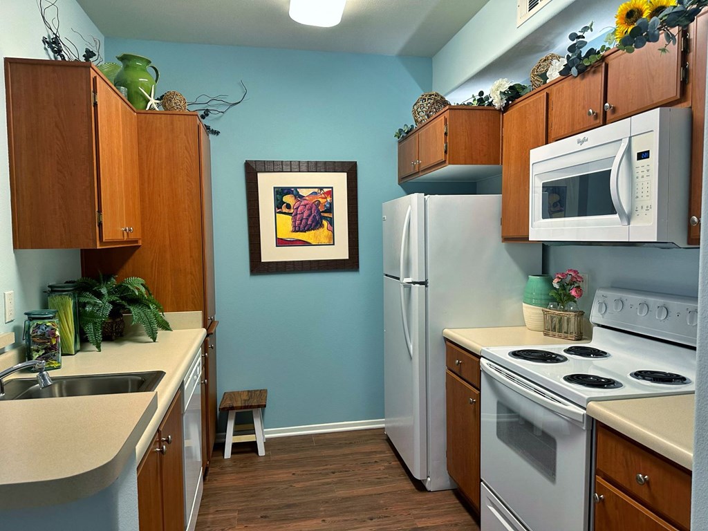 a kitchen with white appliances and wooden cabinets