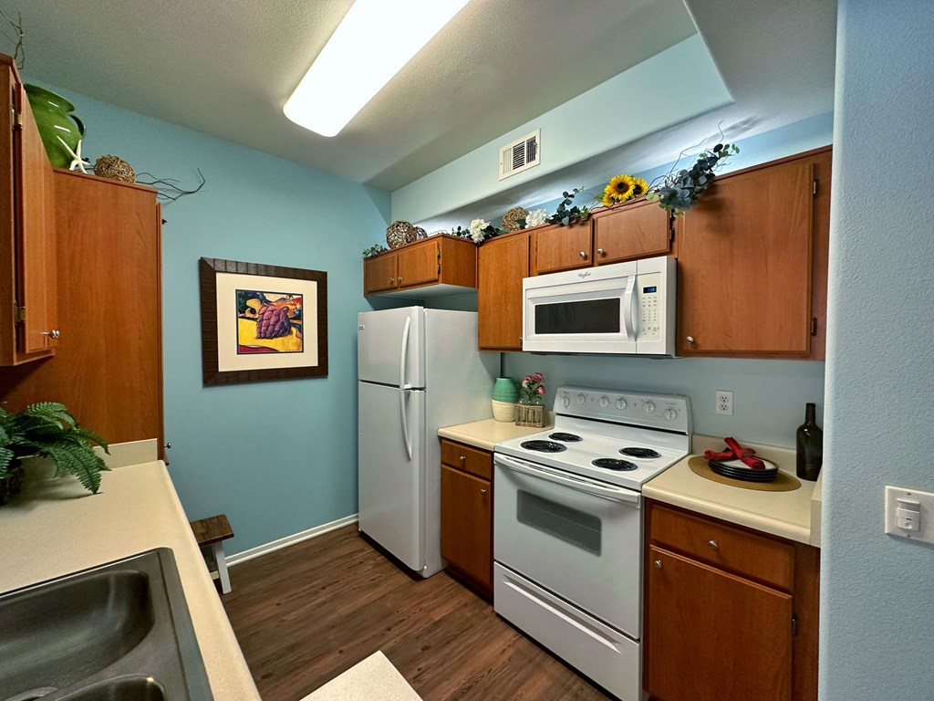 a kitchen with white appliances and wooden cabinets