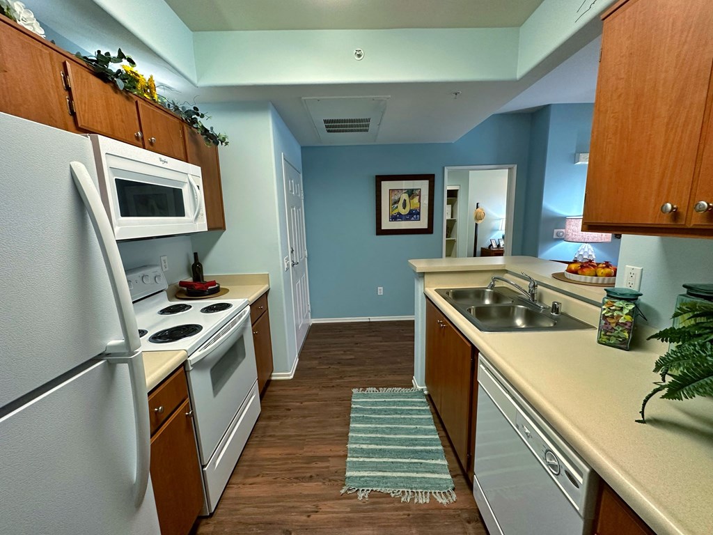 a kitchen with white appliances and wooden cabinets