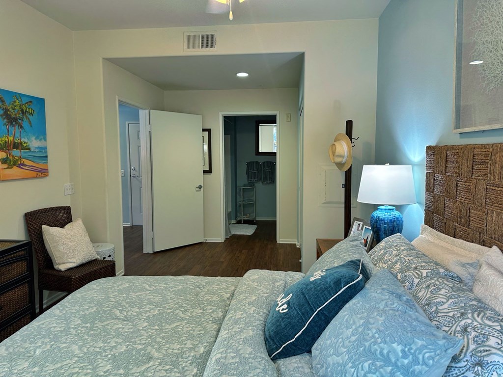 a bedroom with a bed and a couch and a door to a bathroom