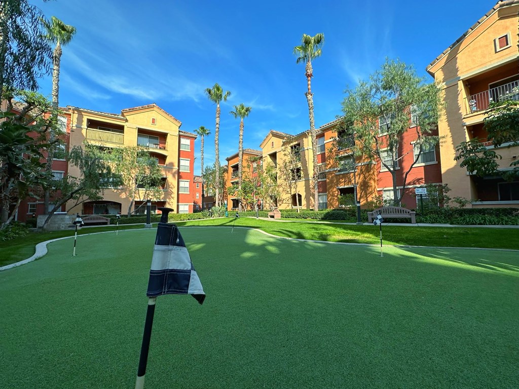 a putting green with apartments in the background