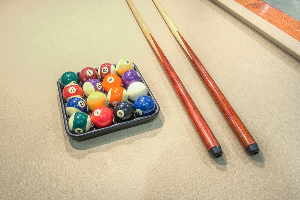 a set of billiard balls and two sticks on a table