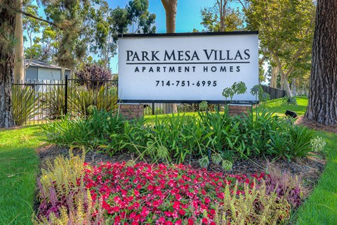 park mesa villas apartments sign in front of a park with flowers