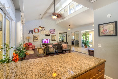 the view of the living room from the kitchen of a house with a large counter