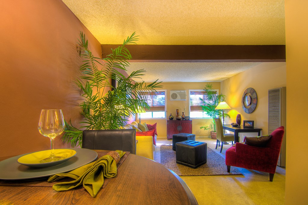 a living room with a table and a glass of wine