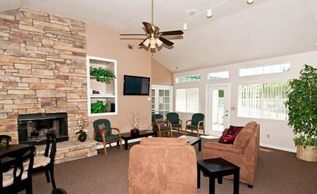a living room with a fireplace and a ceiling fan
